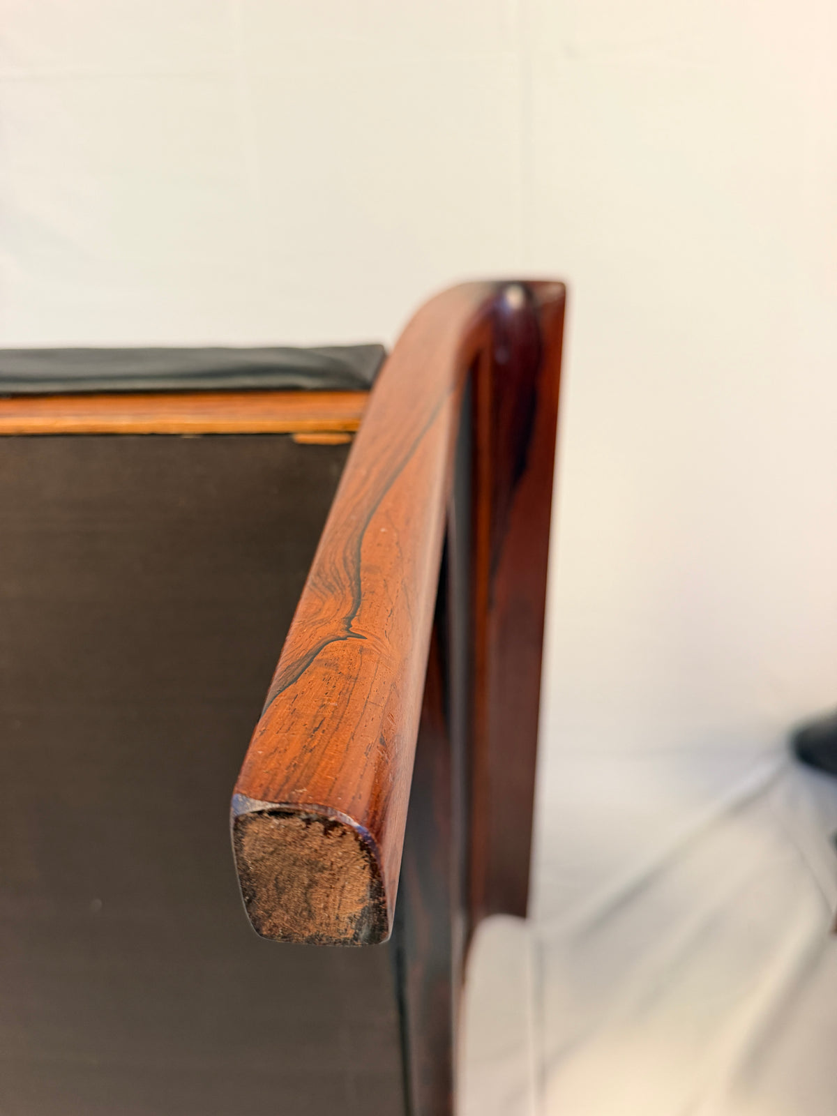 Original closeup of a rosewood lounge chair arm end