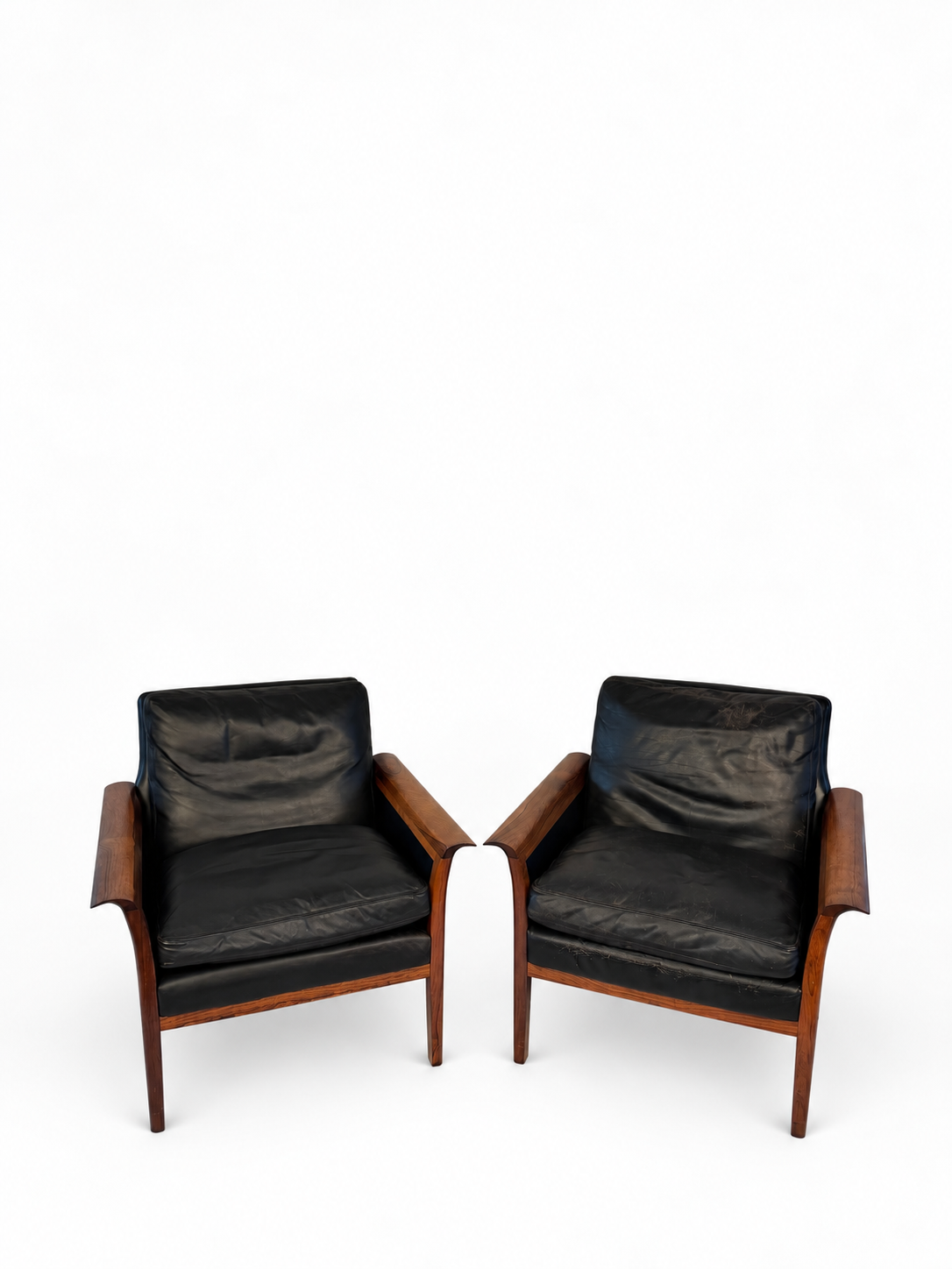 Pair of rosewood and black leather lounge chairs cataloged as Hans Olson, full front view