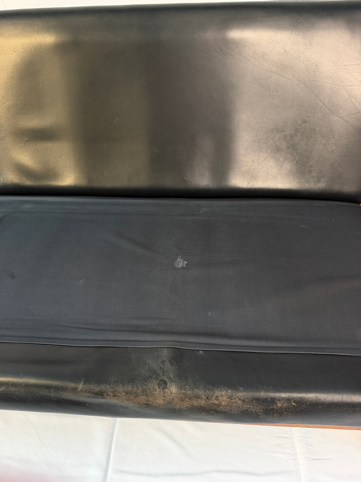 Original closeup of worn leather along the sofa’s lower front edge