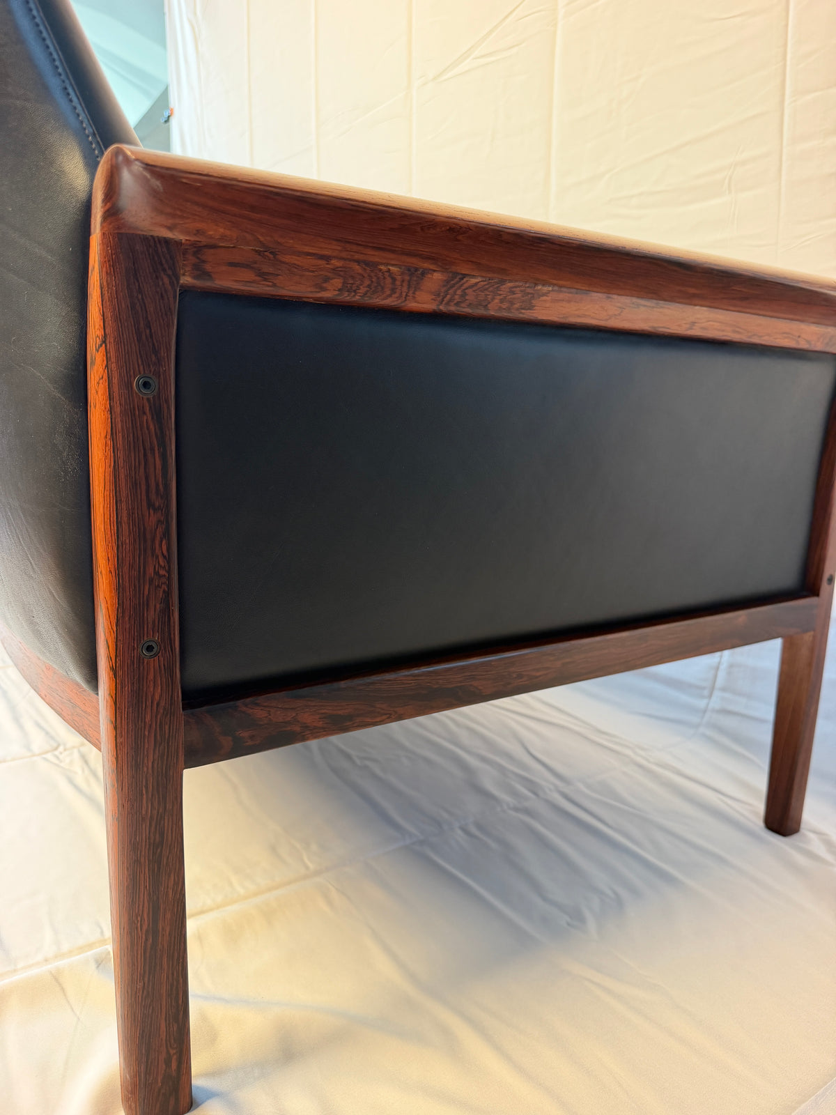 Original detail of the sofa’s rosewood arm and adjacent leather