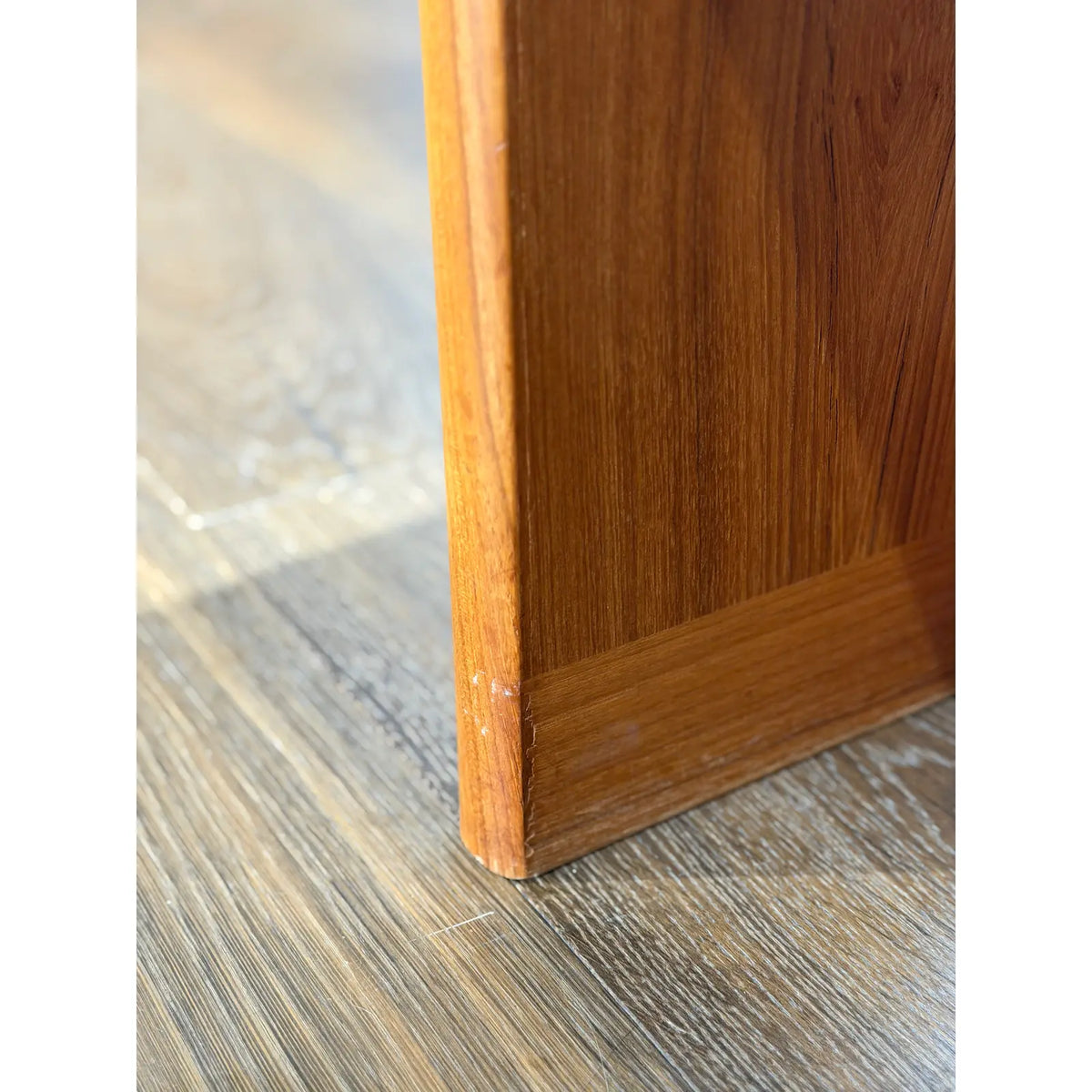 Teak expanding dining table, lower edge of a base panel