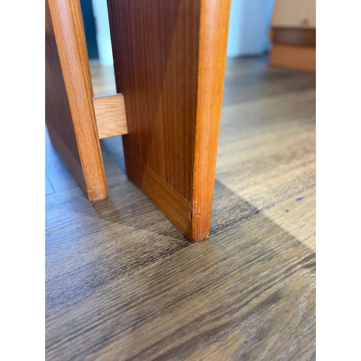 Teak expanding dining table, base-panel edge and adjoining stretcher