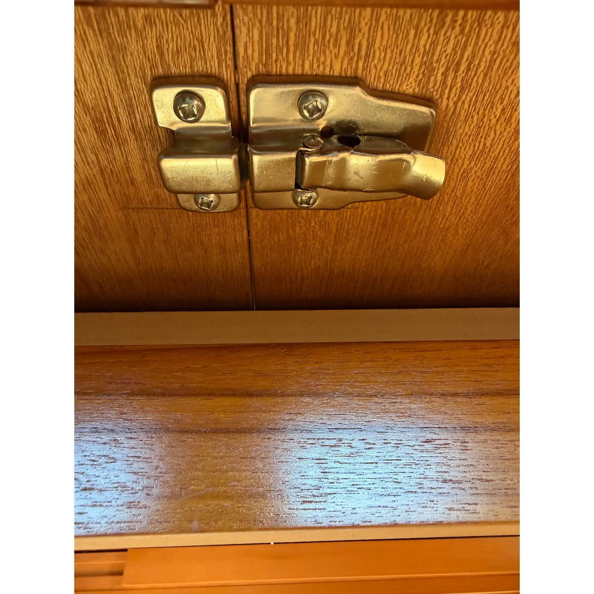 Teak expanding dining table, close view of the metal closing latch