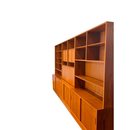 Hundevad teak wall unit with secretary, angled view of the shelving and lower cabinets, on white background