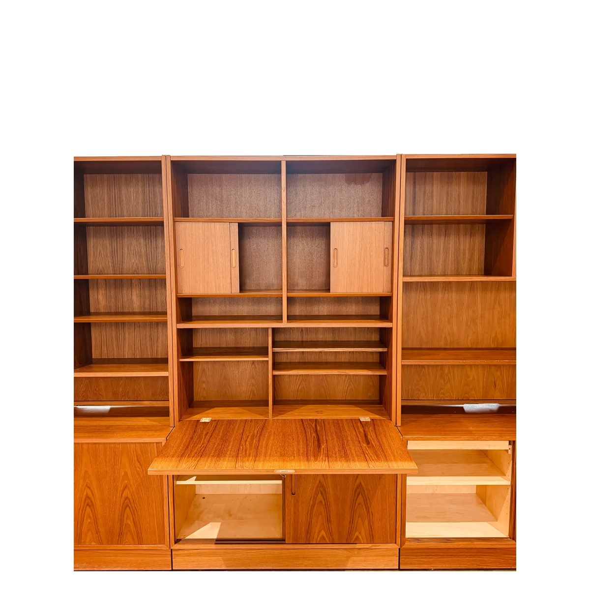 Hundevad teak wall unit with secretary, secretary open with fitted compartments and lower storage exposed, on white background