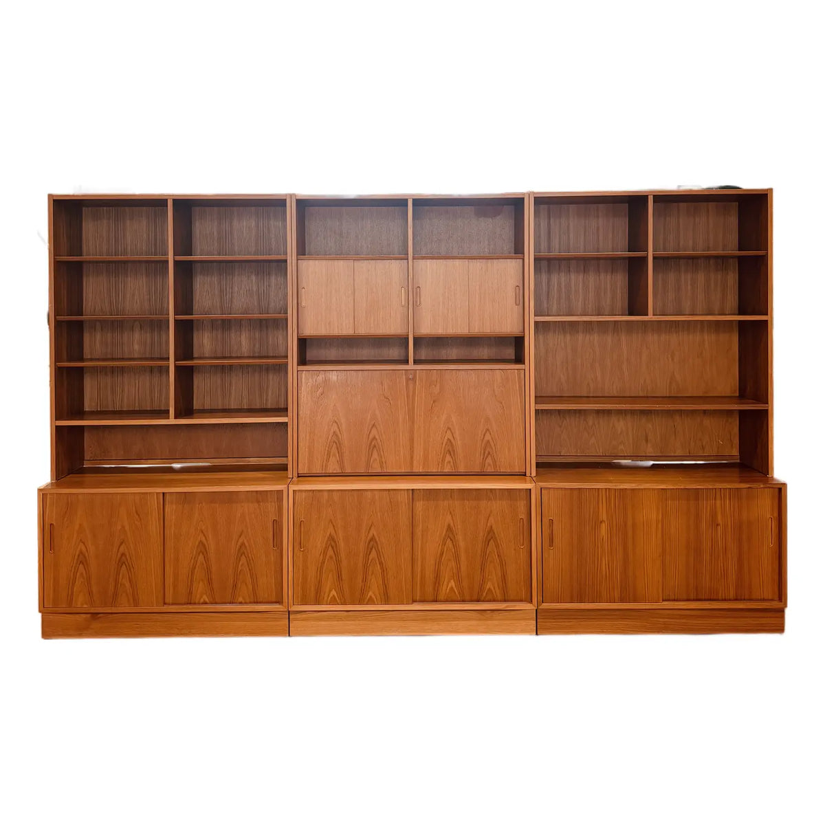 Hundevad teak wall unit with secretary, full front view of the three-module wall system on white